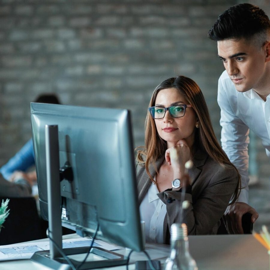 two-young-entrepreneurs-working-computer-reading-email-office_637285-1065